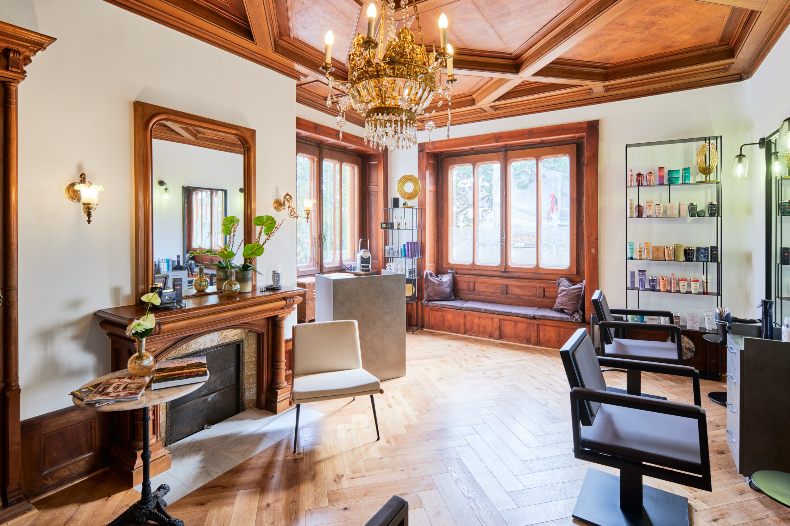 Intérieur du Salon29 à Neuchâtel : plafond boisé, lustre et cheminée d'une maison de maître du XVIIIe siècle